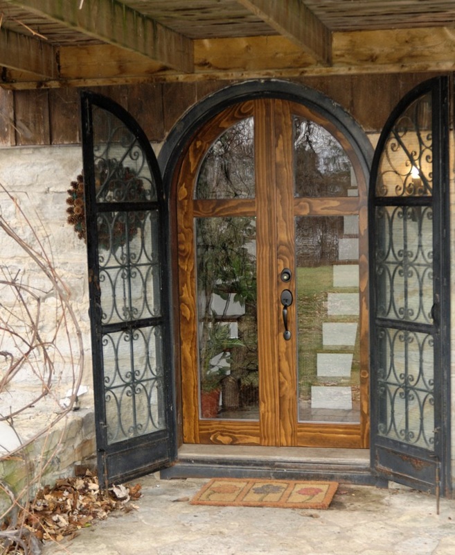 Arched Entrance Door: stained wood, glass.